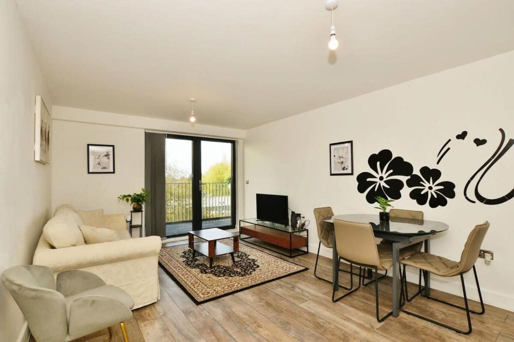 een woonkamer met een bank en een tafel en een eetkamer bij Contemporary 2 bedroom apartment - Ashford in Ashford