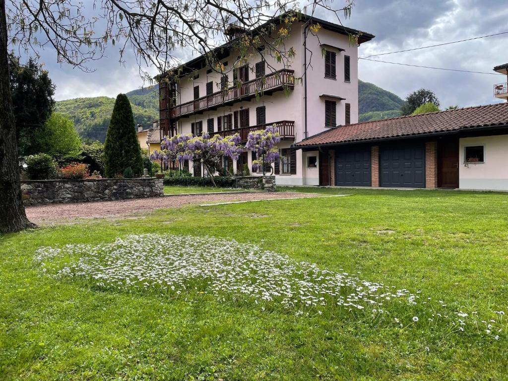 una casa con un patio con flores en el césped en Dimora Fiorita Senior My Holiday Home, en Varallo