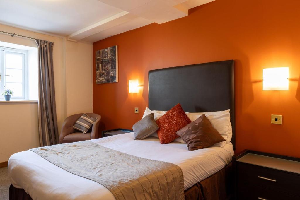 um quarto de hotel com uma cama e uma cadeira em The Warehouse em Yeovil