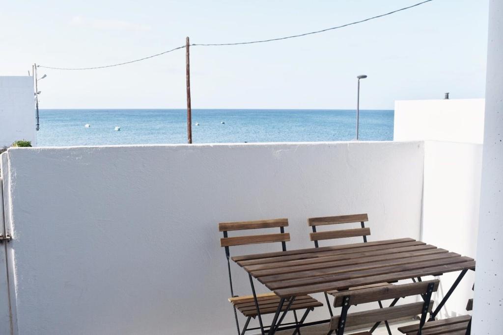 dwa krzesła i drewniany stół na balkonie z widokiem na ocean w obiekcie La Lajita Barca Beach w mieście Lajita