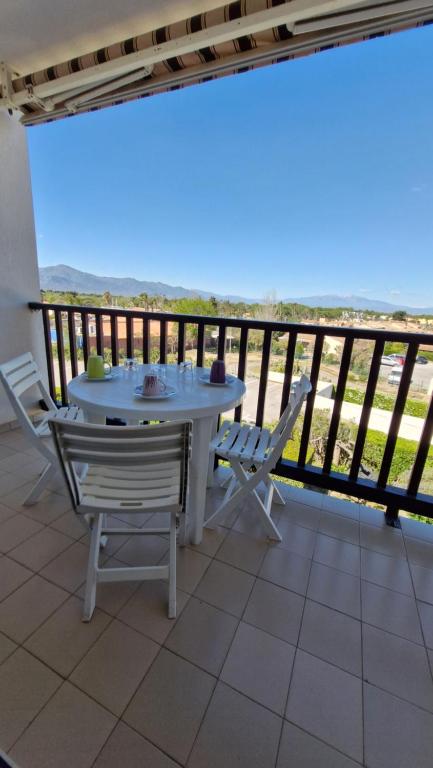 une table et des chaises sur un balcon avec vue dans l'établissement LES CAPITELLES - Studio cabine - Piscine - plage à 50 m Ref Noga, à Saint-Cyprien