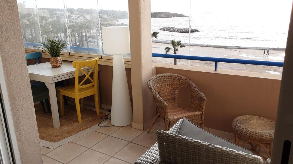 Pokój ze stołem i krzesłami oraz widokiem na ocean w obiekcie Appt T3 VUE MER w mieście Six-Fours-les-Plages