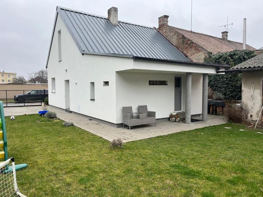 a white house with a patio with a couch at Celý dům + zahrada in Pardubice