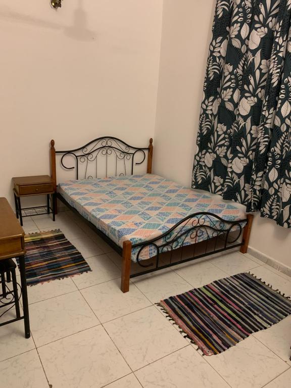 łóżko w pokoju z dywanami na podłodze w obiekcie BRISE DE MER : 2 ROOM / CHAMBRES w mieście Dżibuti