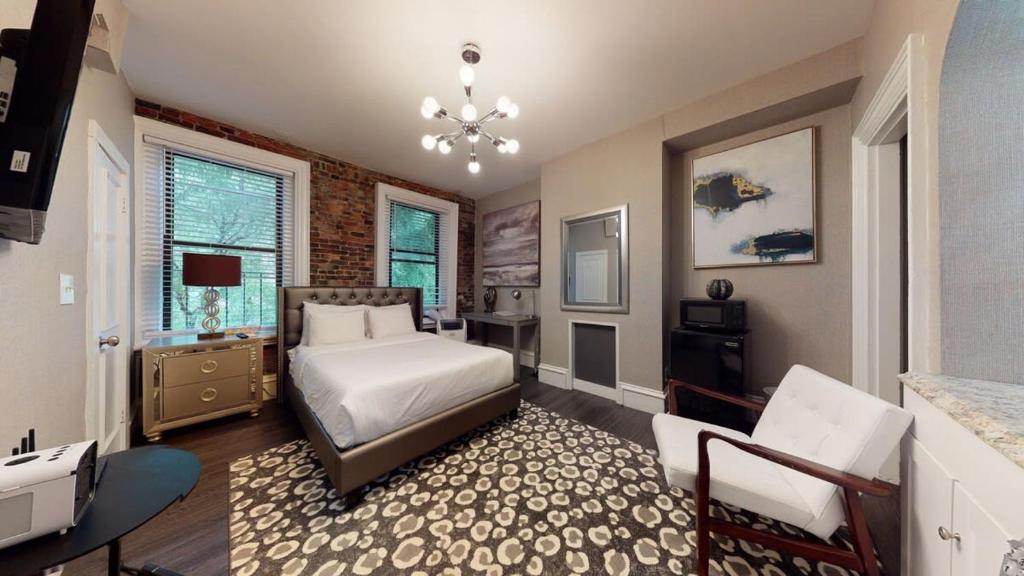 - une chambre avec un lit et une chaise dans l'établissement L 3-33 Stylish Private Studio in Boston!, à Boston