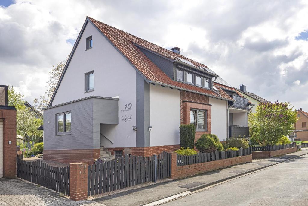 una casa blanca con una valla negra en Ferienwohnung Harzreich, en Seesen