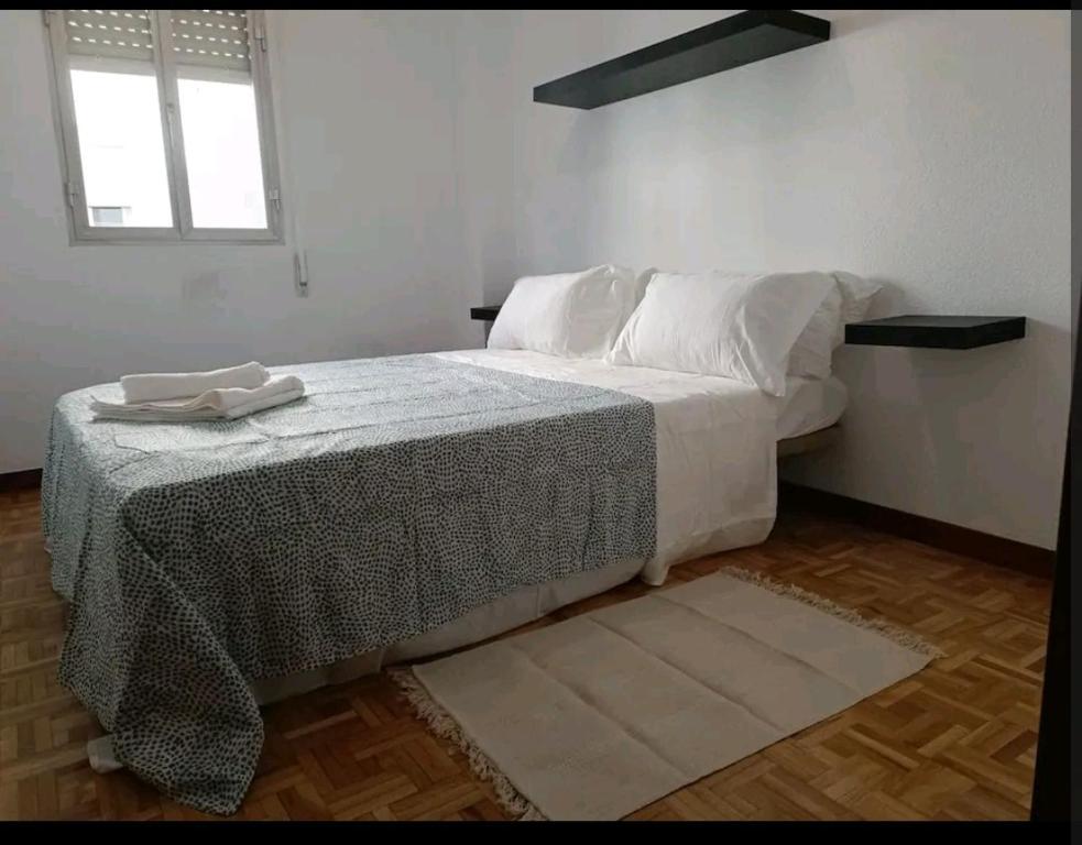 1 dormitorio con 1 cama con sábanas blancas y ventana en luminosa habitación en vallecas, en Madrid