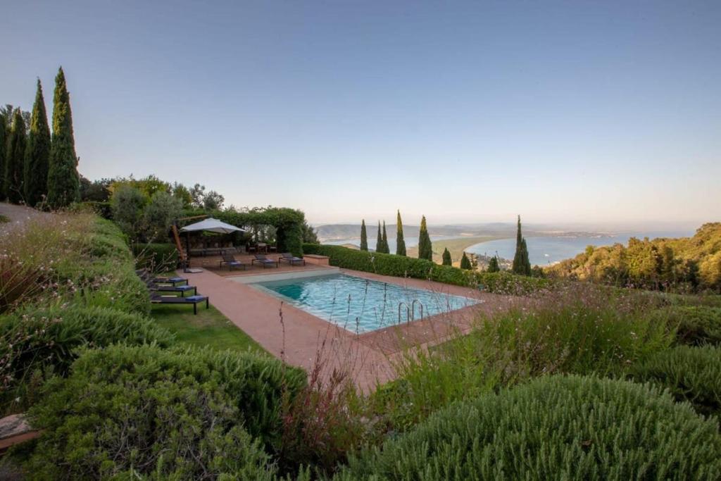 a swimming pool in the middle of a garden at Villaflair - Sea View Porto Ercole in Porto Ercole