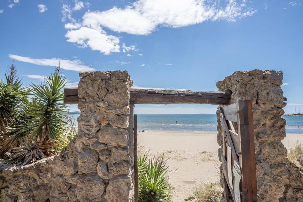 ein altes Steintor zum Strand in der Unterkunft Villaflair - Feniglia Beach House in Cala Galera