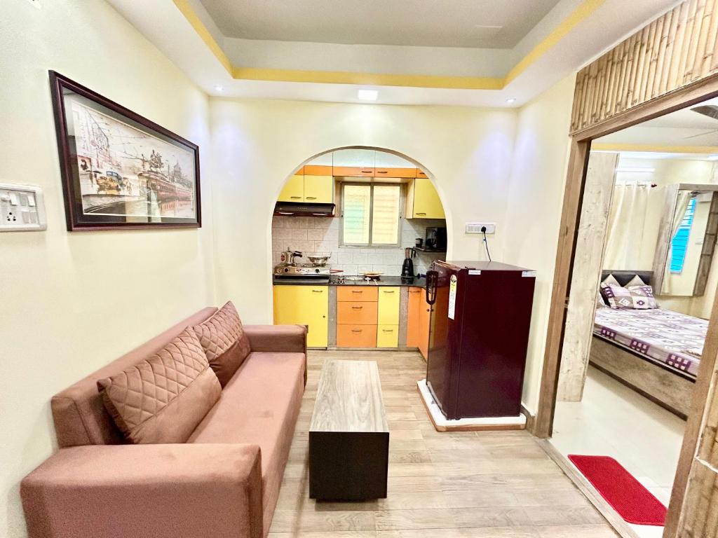 a living room with a couch and a kitchen at Stylish 1RK Serviced Apartment in Tollygunge in Kolkata