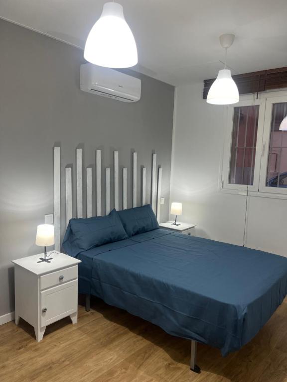 1 dormitorio con 1 cama azul y 2 mesitas de noche en Apartamento exclusivo en Madrid, en Madrid