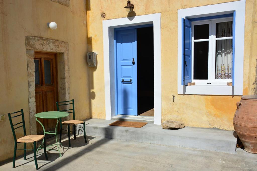 drzwi ze stołem i krzesłami przed budynkiem w obiekcie Vori`s blue door country house w mieście Vóroi