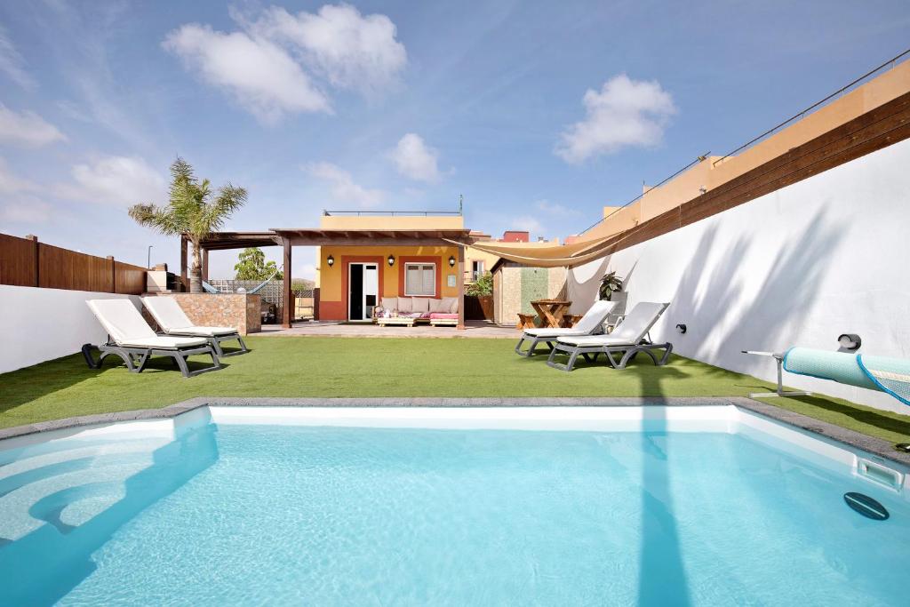 a swimming pool in the backyard of a house at Villa del Relax in Corralejo