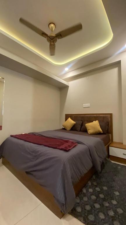 a bedroom with a bed with a ceiling fan at M premium executive apartment in Bangalore