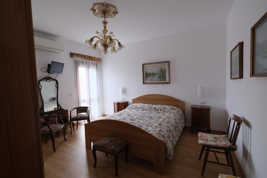 1 dormitorio con 1 cama, mesa y sillas en Casa degli Artisti, en Burano