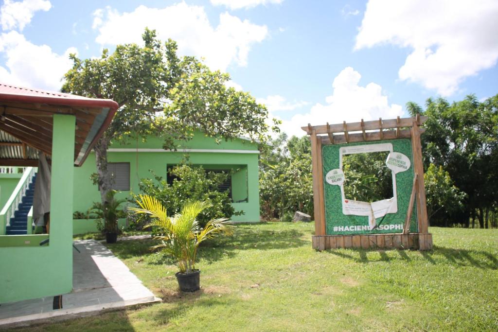 a green house with a sign in the yard at Hacienda Familiar en Hato Mayor del Rey 