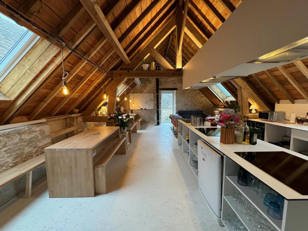 a large kitchen with wooden ceilings and wooden counters at LES BRIQUES in Lion-sur-Mer