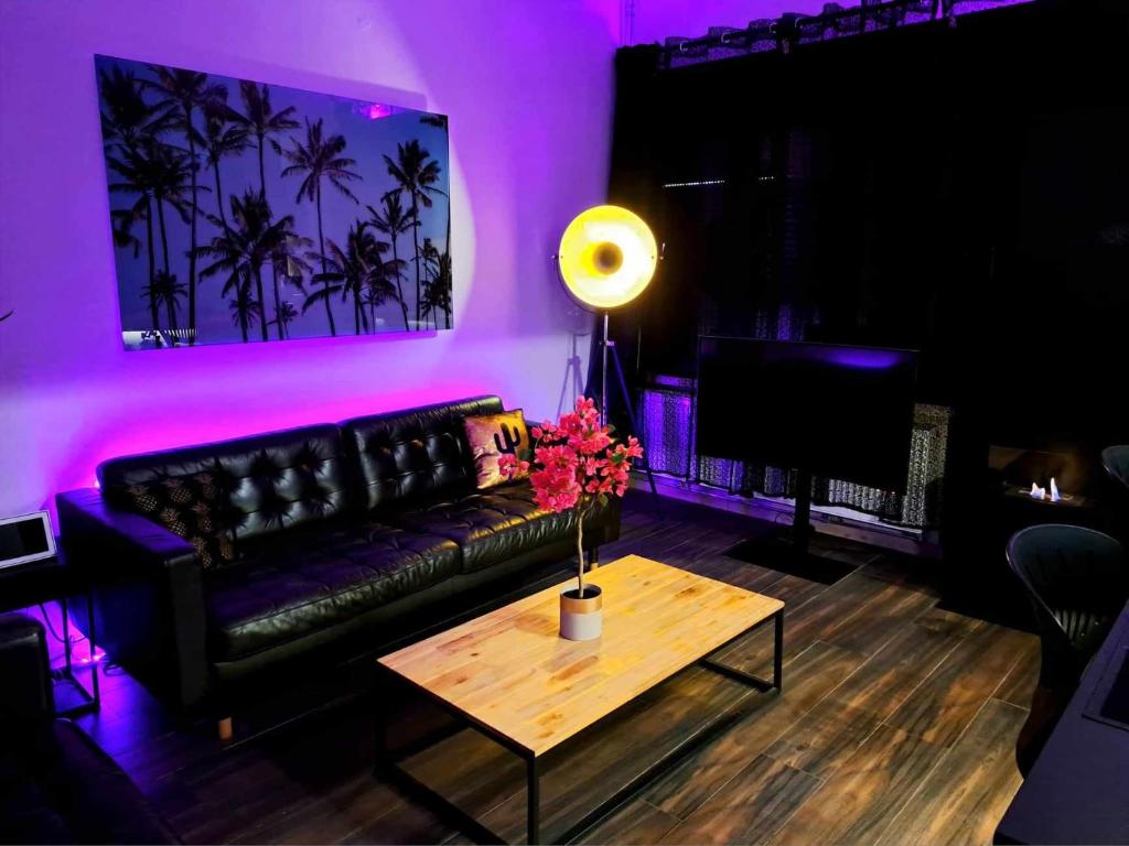 a living room with a black couch and a table at chambre avec 2 lits séparé dans une maison l'hote in Liège
