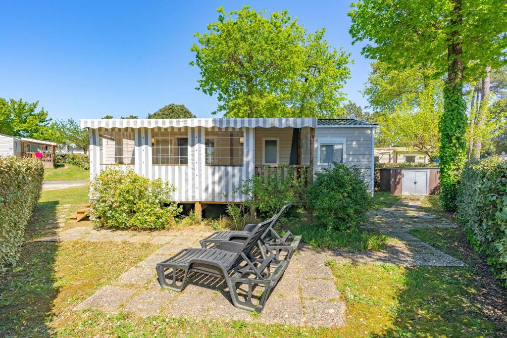 un banc devant une petite maison dans l'établissement Mh 169 Ronce les bains, à La Tremblade