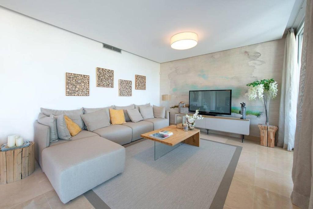 sala de estar con sofá y TV en LUXURY PENTHOUSE MARBELLA WIFI POOLS NETFLIX GOLF, en Benahavís