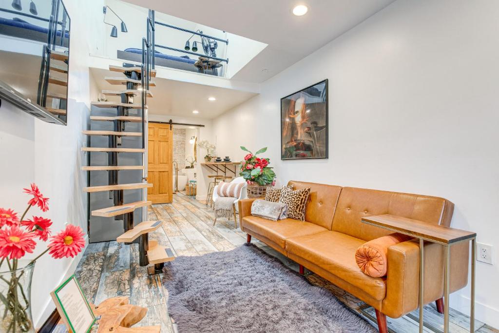 a living room with a couch and a spiral staircase at Denver Tiny House Walk to Cafes, Bars, Eateries! in Denver