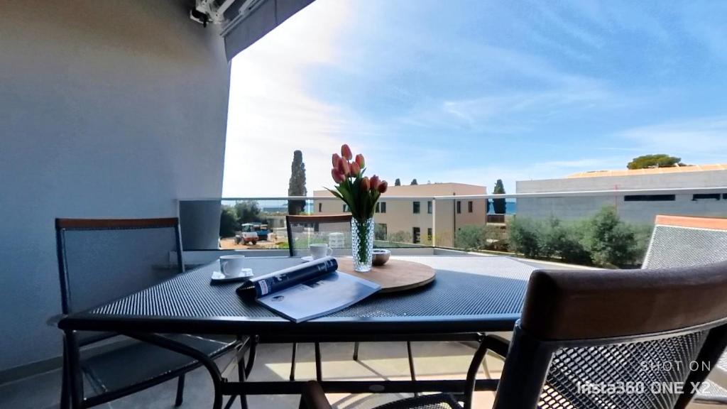 ein Tisch und Stühle auf einem Balkon mit Aussicht in der Unterkunft Apartment Perlita in Fažana