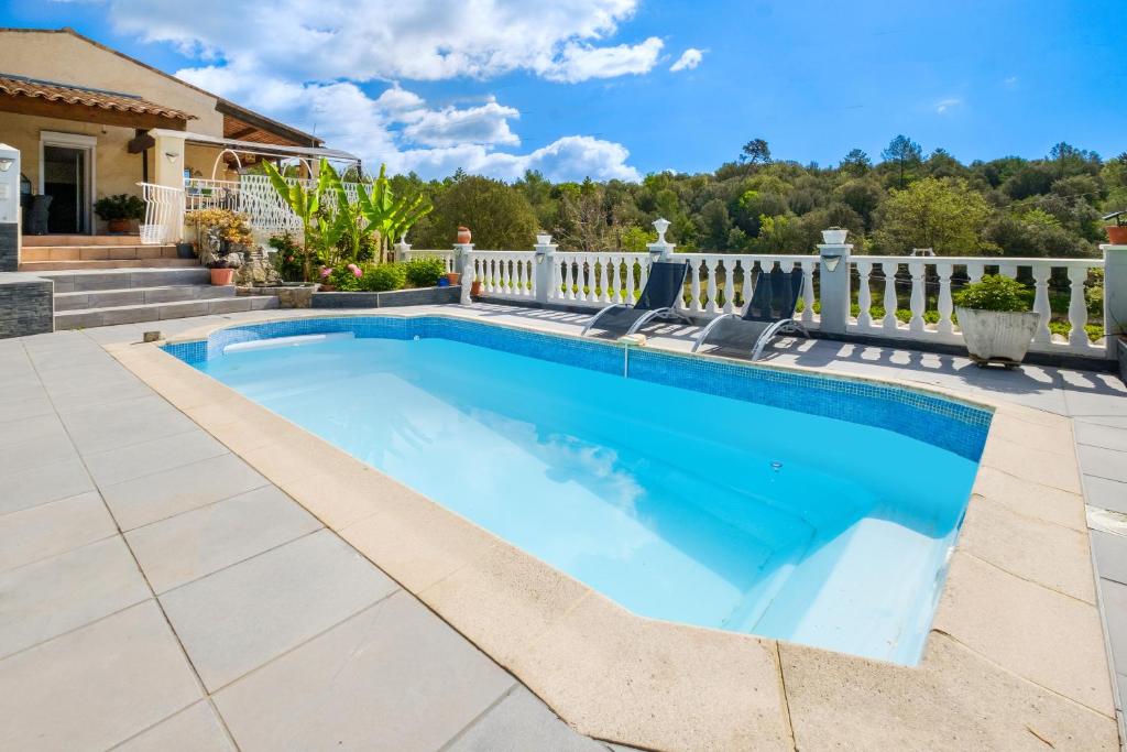 einen Pool im Hinterhof mit einem weißen Zaun in der Unterkunft Villa 6 pers avec piscine in Le Tignet