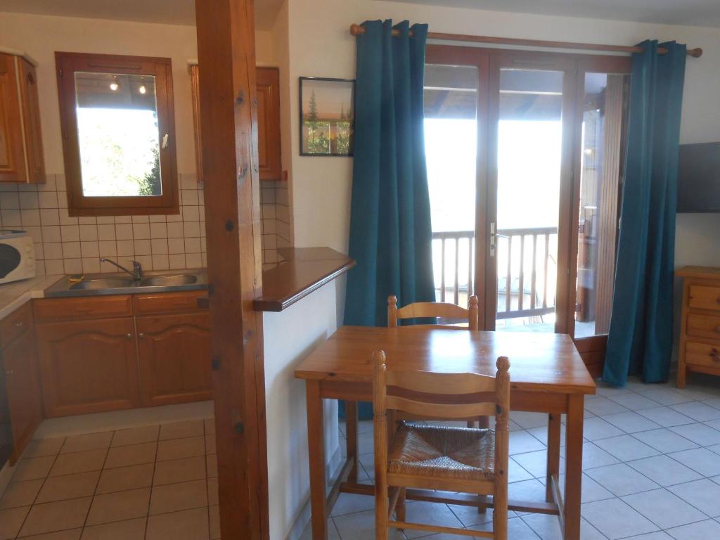 Una cocina con una mesa de madera y un comedor. en Entre lac et montagnes, en Savines