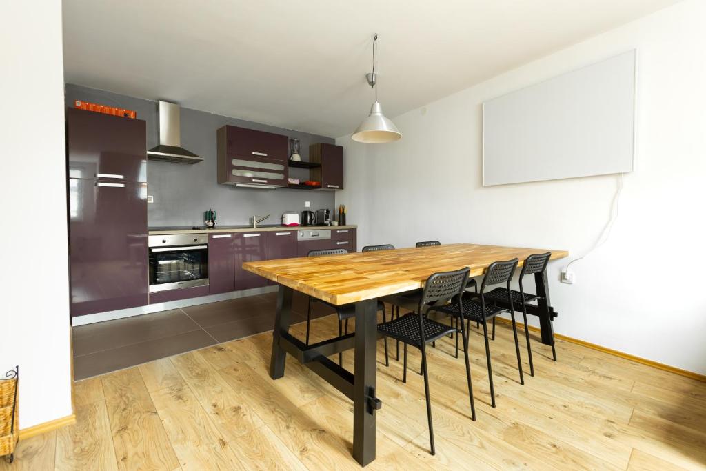 Una cocina con una mesa de madera y sillas negras. en Svarun apartment, en Bovec