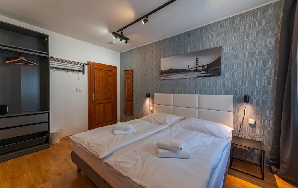 a bedroom with a large white bed and a television at Villa Margarita in Český Krumlov