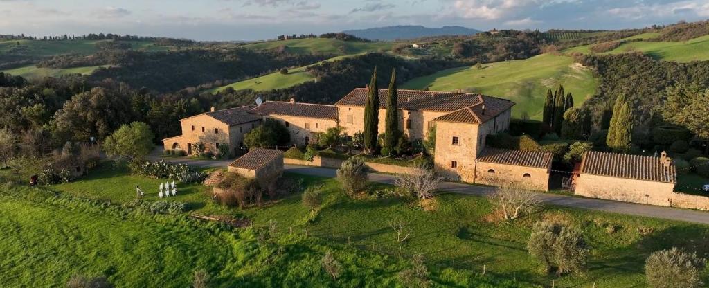 an aerial view of a house in a green field at Le Valli Tuscany in Pomarance