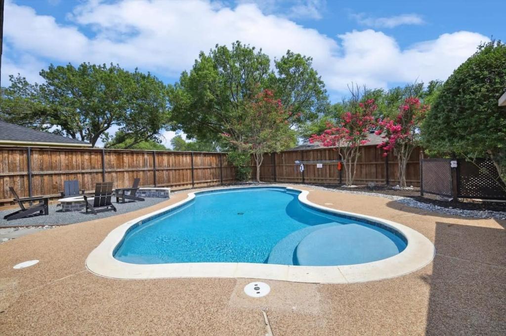 a swimming pool in a backyard with a fence at Allen Abode - 4 Bedrm Pool Fire Pit Charm in Allen
