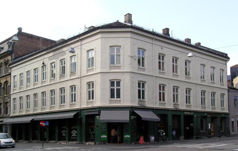 um grande edifício branco na esquina de uma rua em Torggata Suite Apartments em Oslo
