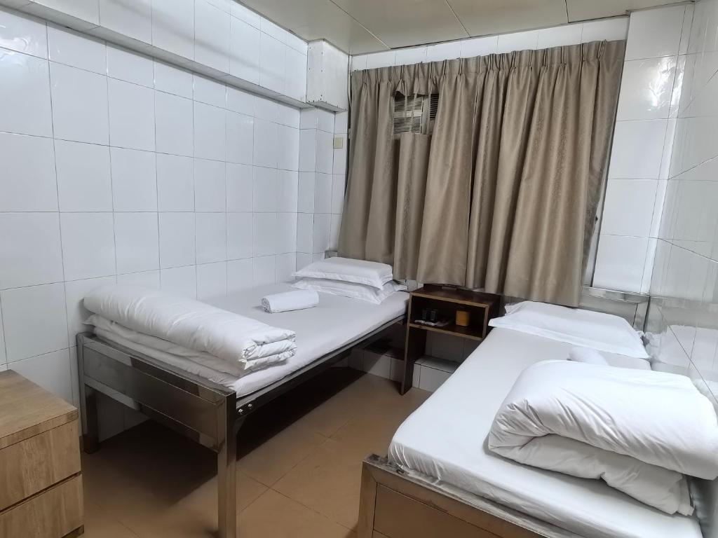 Rúm í herbergi á Jinnsti Guesthouse 景士迪宾馆