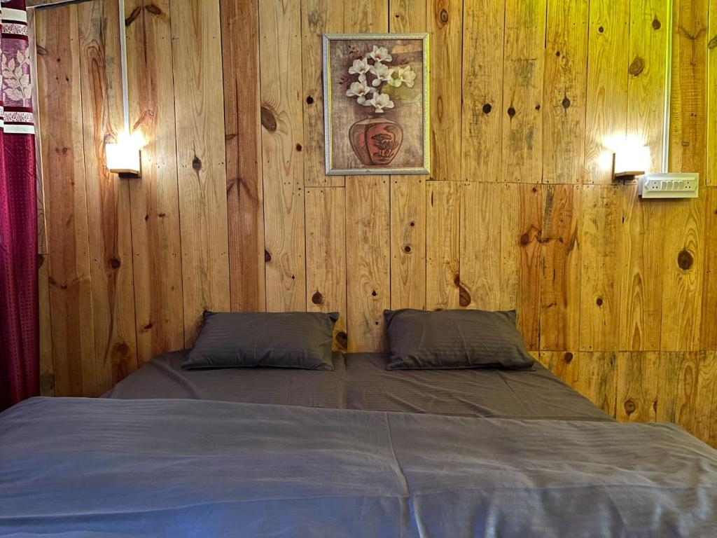 1 dormitorio con 1 cama en una pared de madera en Peace space resort, en Nainital