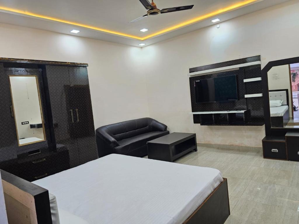 Habitación con cama, silla y TV. en Goroomgo Gautam Garden Varanasi - Best Location & Parking Facilities en Varanasi