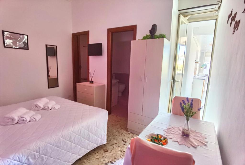um quarto rosa com 2 camas e 2 cadeiras em Luxury Sisters House "La Buganvilla" em Catânia