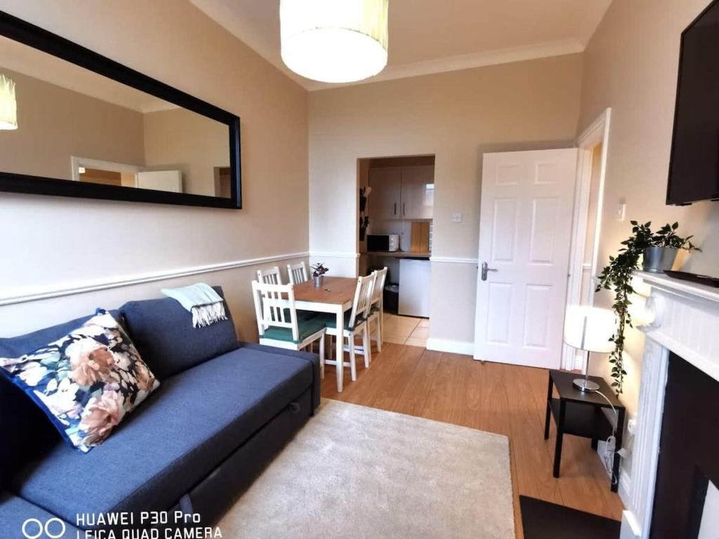 a living room with a blue couch and a table at CENTRAL LOCATION 2 BED APT Fast WIFI & TV&KITCHEN in Dublin