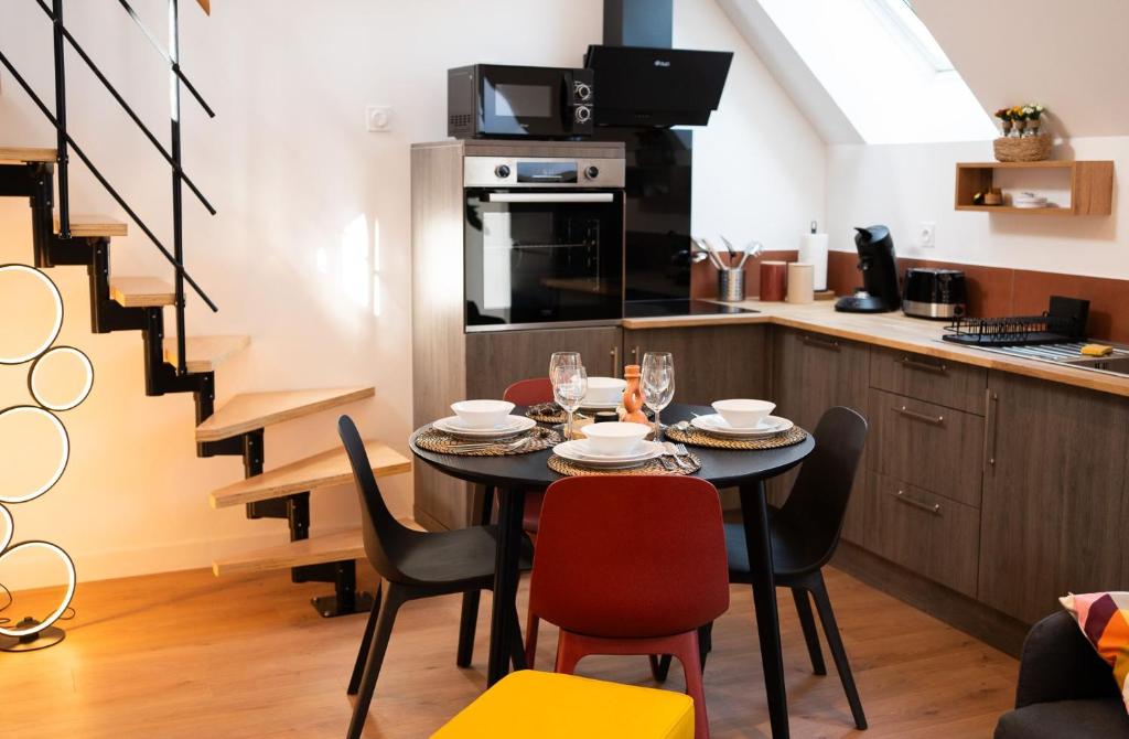 a kitchen and dining room with a table and chairs at Appartements plein centre, à 5 minutes du château in Onzain