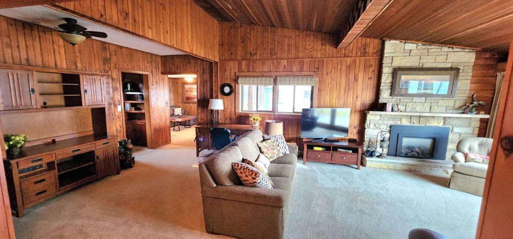 sala de estar con sofá y TV en The River Cabin, en Wabasha