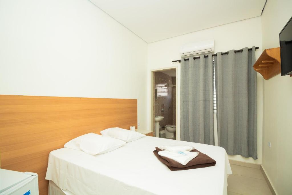 1 dormitorio con cama blanca y ventana en Hotel Ourinhos - Centro de São Paulo - Próximo 25 de Março e Brás - By Up Hotel, en São Paulo