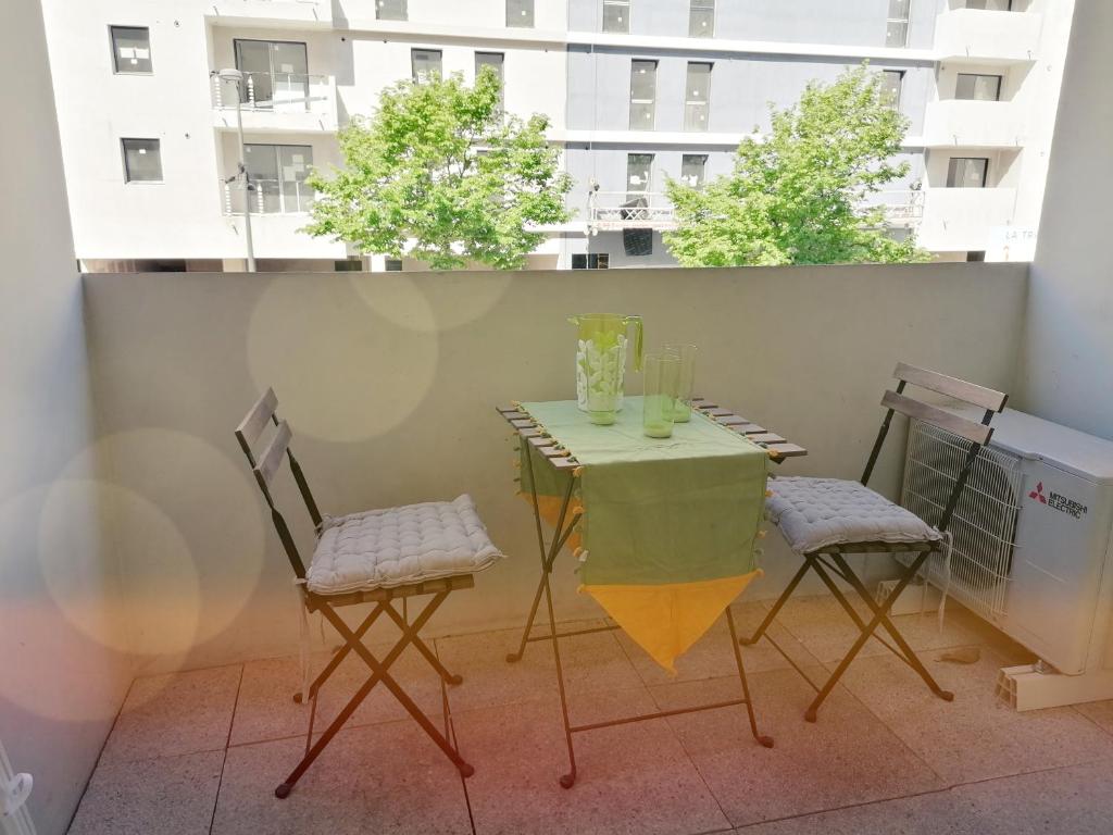 une table et deux chaises sur un balcon dans l'établissement La Major, Appartement urbain + Parking, à Marseille