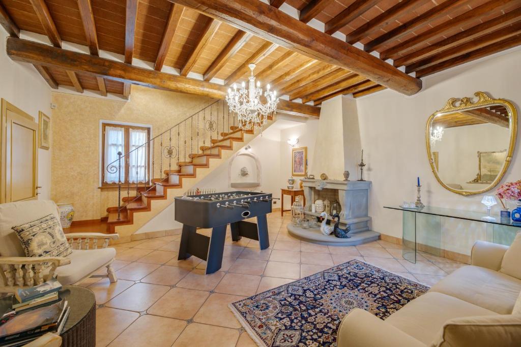 un salon avec une table et un escalier dans l'établissement Corte della Luna, à Cortone