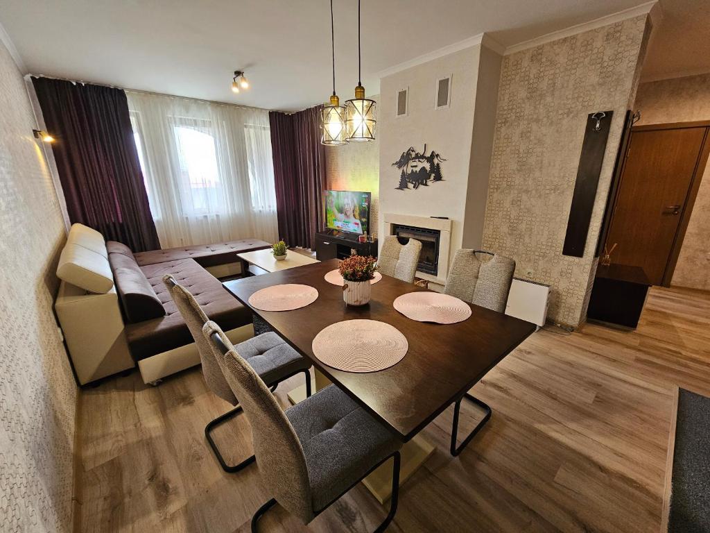 a dining room and living room with a table and chairs at Viva 5 apartment Grand Monastery on the ski slopes in Pamporovo