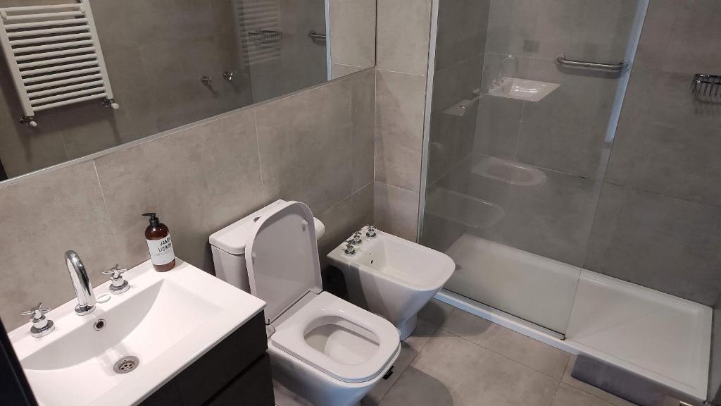 y baño con aseo, lavabo y ducha. en Depto moderno con estacionamiento/ AlquilaMiCasa en San Martín de los Andes