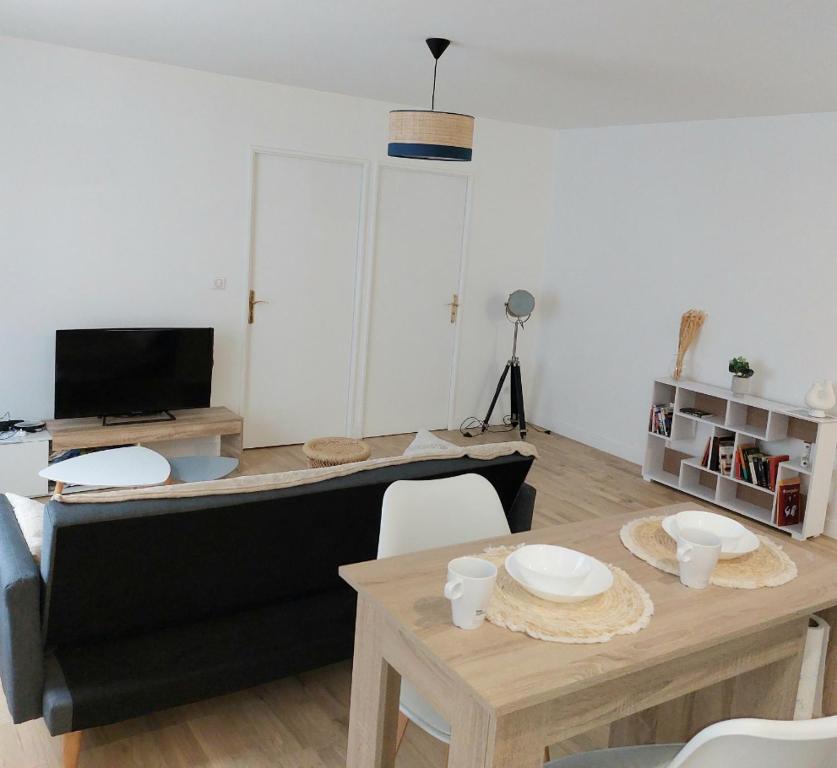 een woonkamer met een bank en een tafel bij Cosy Flat - Stade de France in Saint-Denis
