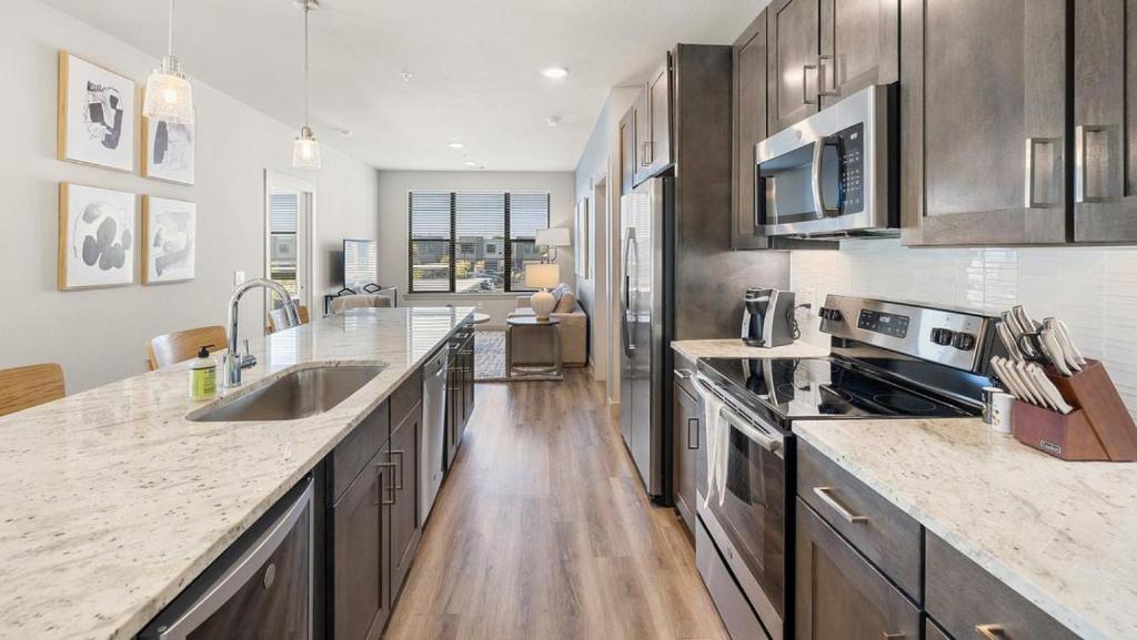 a kitchen with stainless steel appliances and wooden floors at Landing at 11th and Spruce - 2 Bedrooms in Downtown in Saint Louis