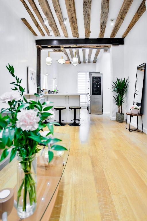 une chambre avec un vase de fleurs sur une table dans l'établissement Marais 4 bedrooms new apartment, à Paris