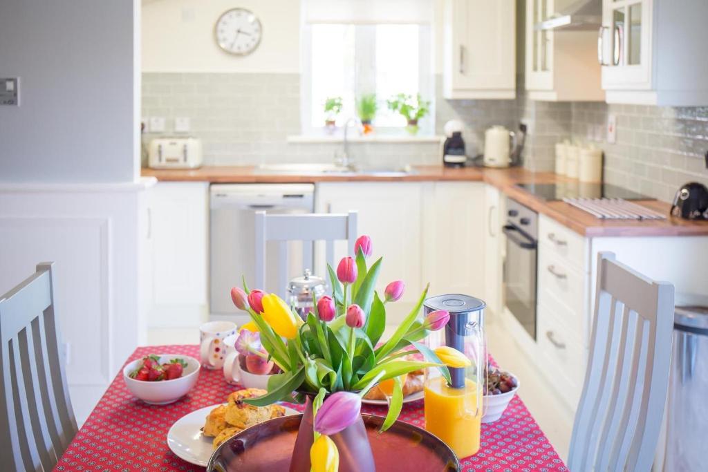 una cocina con una mesa con flores. en Connemara Letting's Townhouse en Clifden