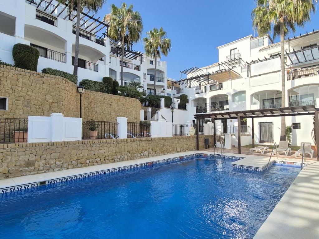 una grande piscina di fronte a un edificio di Apartamento en Los Monteros a Marbella